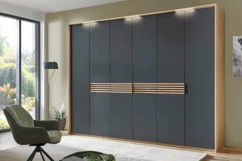 Moderner Kleiderschrank mit dunklen Fronten und Holzdetails, beleuchtetem Rahmen und stilvollem Design.