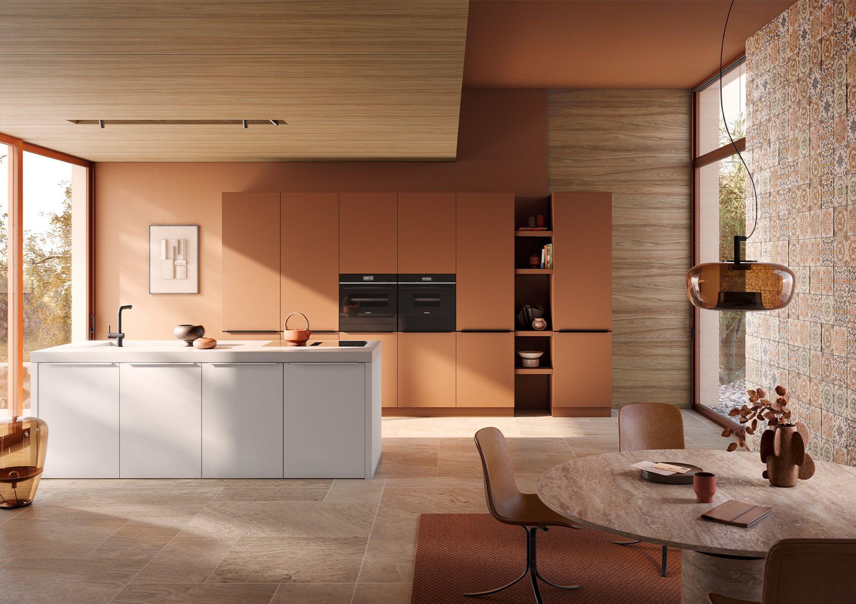 Eine moderne Küche mit einem weißen Kücheninseln, braunen Wandschränken und großen Fenstern, die viel Tageslicht hereinlassen. Der Raum ist mit eleganten Einrichtungsgegenständen und einem runden Esstisch ausgestattet.