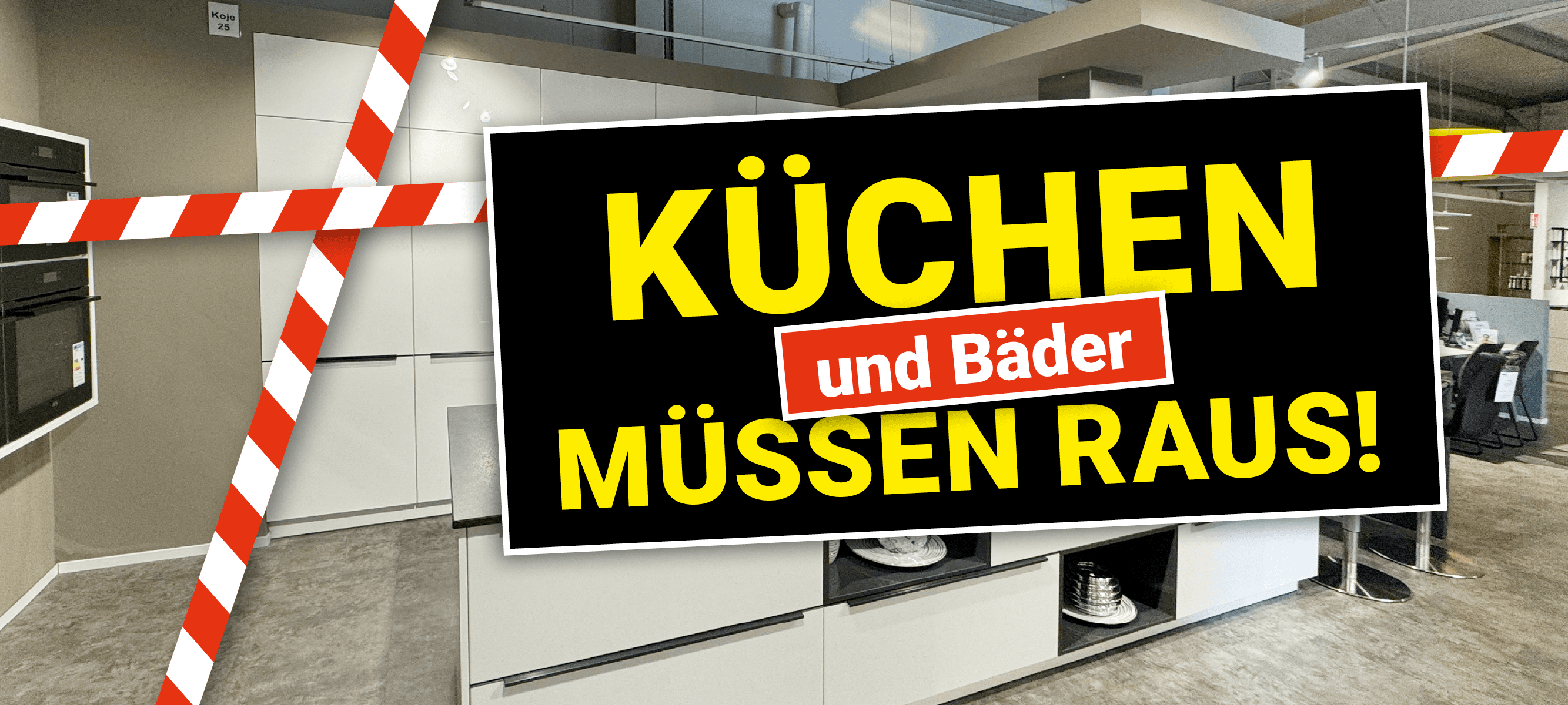 Schwarzes Aktionsbanner mit gelber Schrift vor leerem Ausstellungsraum. Schriftzug: „Küchen und Bäder müssen raus!"
