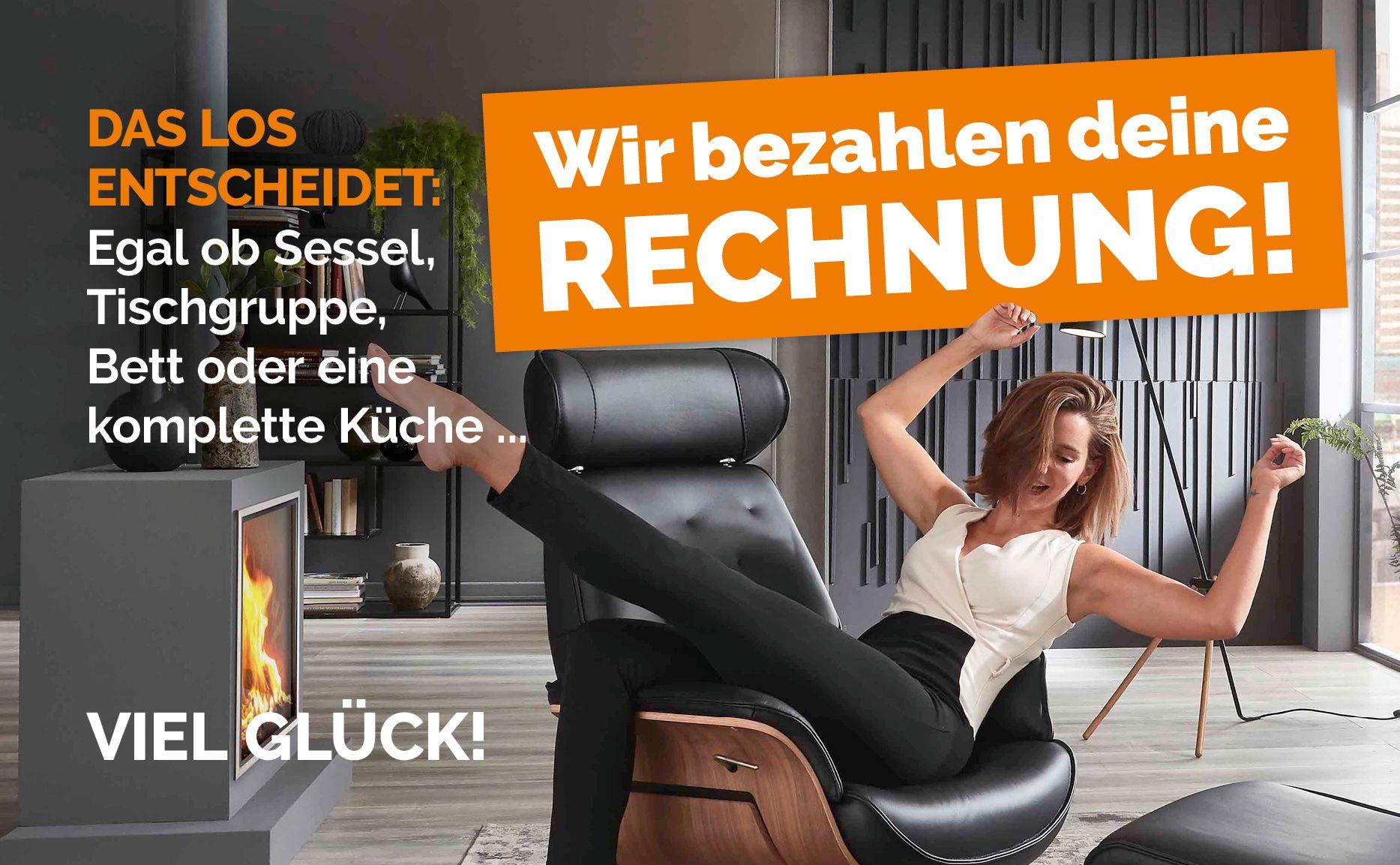 „Frau sitzt entspannt in einem Sessel und freut sich, während sie ihre Beine in die Luft wirft. Im Hintergrund ein moderner Kamin. Text: 'Das Los entscheidet: Egal ob Sessel, Tischgruppe, Bett oder eine komplette Küche... Wir bezahlen deine RECHNUNG! VIEL GLÜCK!
