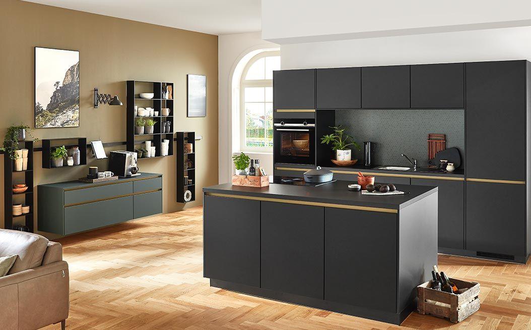 Moderne schwarze Küche mit goldenen Akzenten und Kochinsel, kombiniert mit offener Wohnraumgestaltung; stilvolle Regale an der Wand und Dekorationen schaffen eine warme, einladende Atmosphäre.