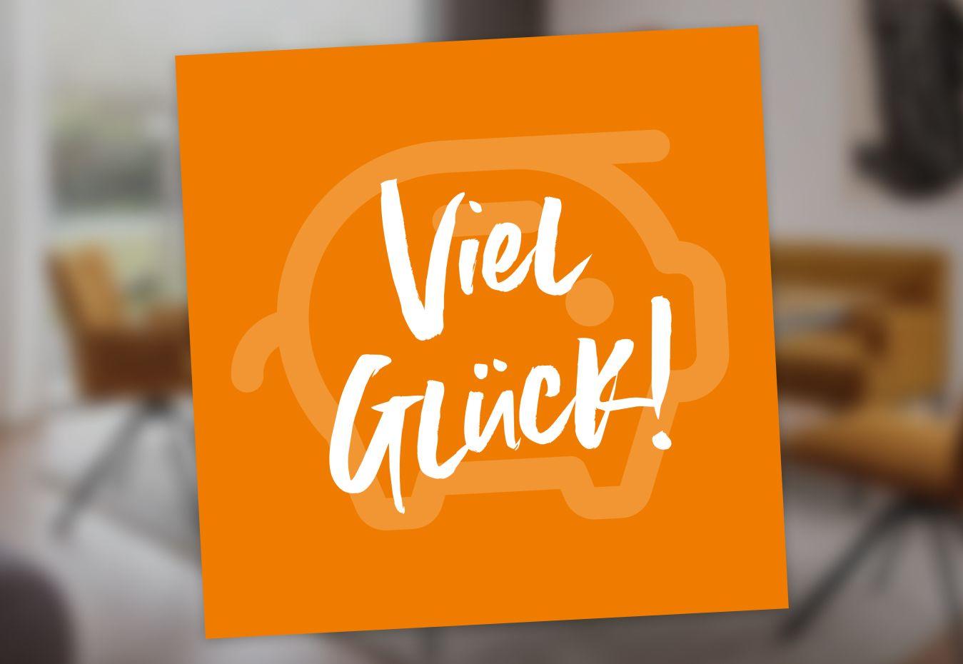 Text 'Viel Glück!' auf einem orangefarbenen Hintergrund mit einem Sparschwein-Symbol im Hintergrund.