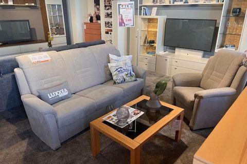 Bequemer Luxea Sessel mit Hocker in einem hellen Wohnzimmer, perfekt für Entspannung.