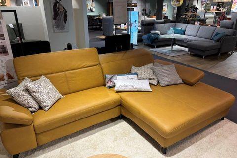 Senfgelbe Couch mit Kissen mit ausgeklapptem Sitzbereich, zeigt Flexibilität und Funktionalität.