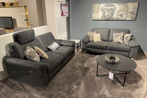 2  Einzelsofas  in dunkelgrau mit Hellen Kissen und rundem Couchtisch