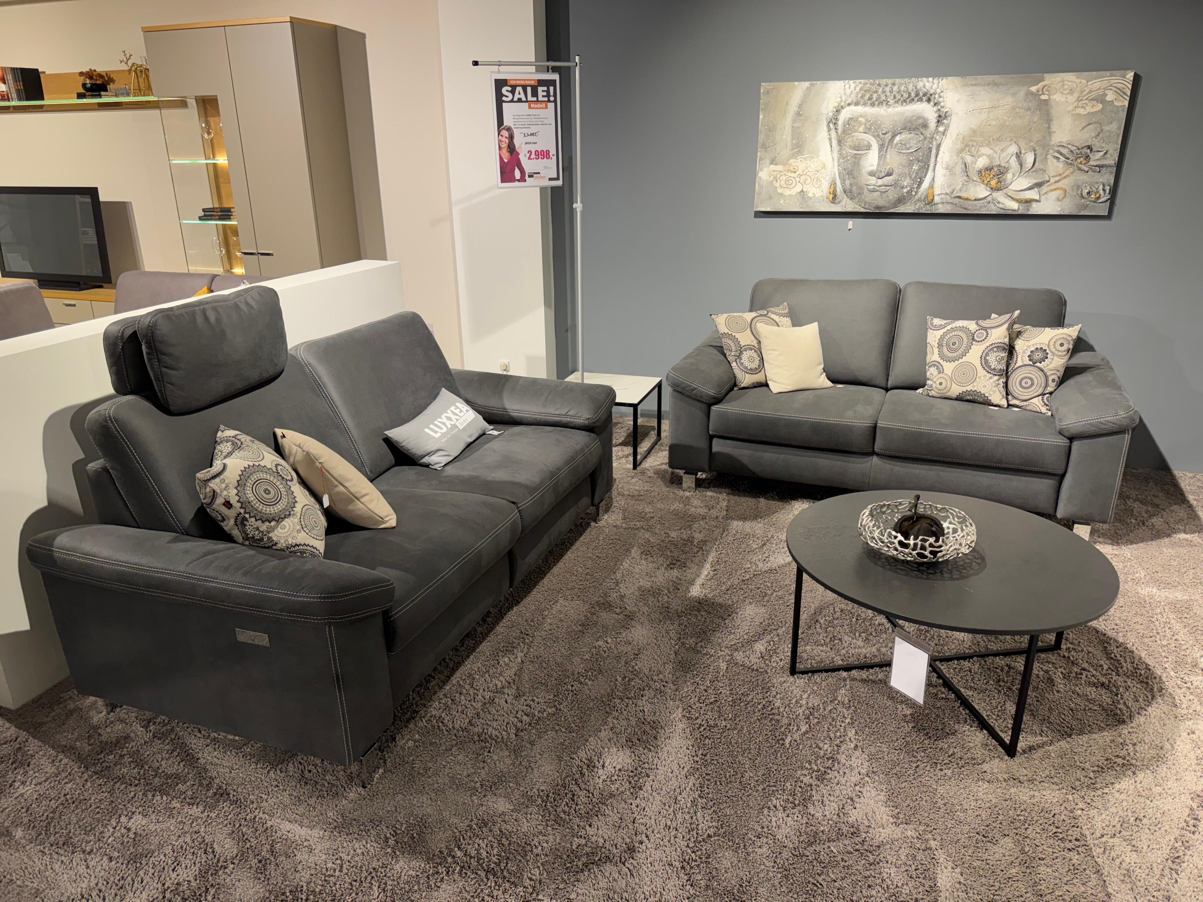 2  Einzelsofas  in dunkelgrau mit Hellen Kissen und rundem Couchtisch