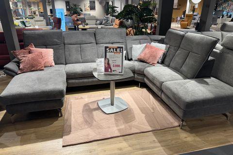 Sofa in U-Form mit grauem Bezug rosanen und grauen Kissen