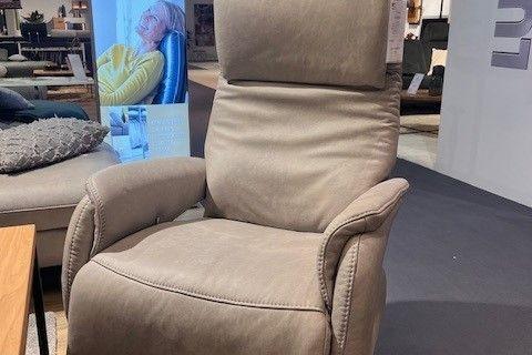 Beigefarbener Relaxsessel mit ergonomischer Polsterung und schwarzem Drehgestell, ausgestellt in einem modernen Möbelraum.