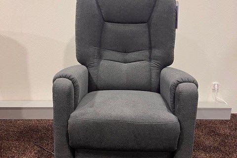 Dunkelgrauer TV-Sessel mit ergonomischer Polsterung und hoher Rückenlehne, aufgestellt auf einem braunen Teppich.