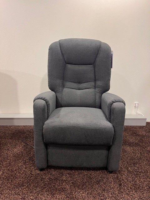 Dunkelgrauer TV-Sessel mit ergonomischer Polsterung und hoher Rückenlehne, aufgestellt auf einem braunen Teppich.