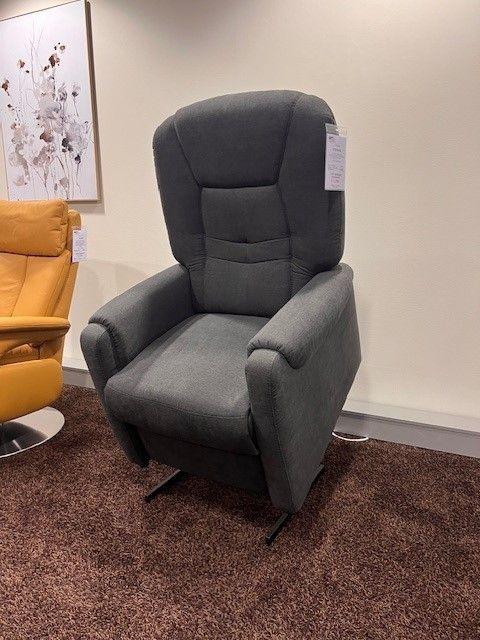 Dunkelgrauer TV-Sessel mit integrierter Aufstehhilfe und ergonomischer Polsterung, präsentiert in einem modernen Möbelraum.