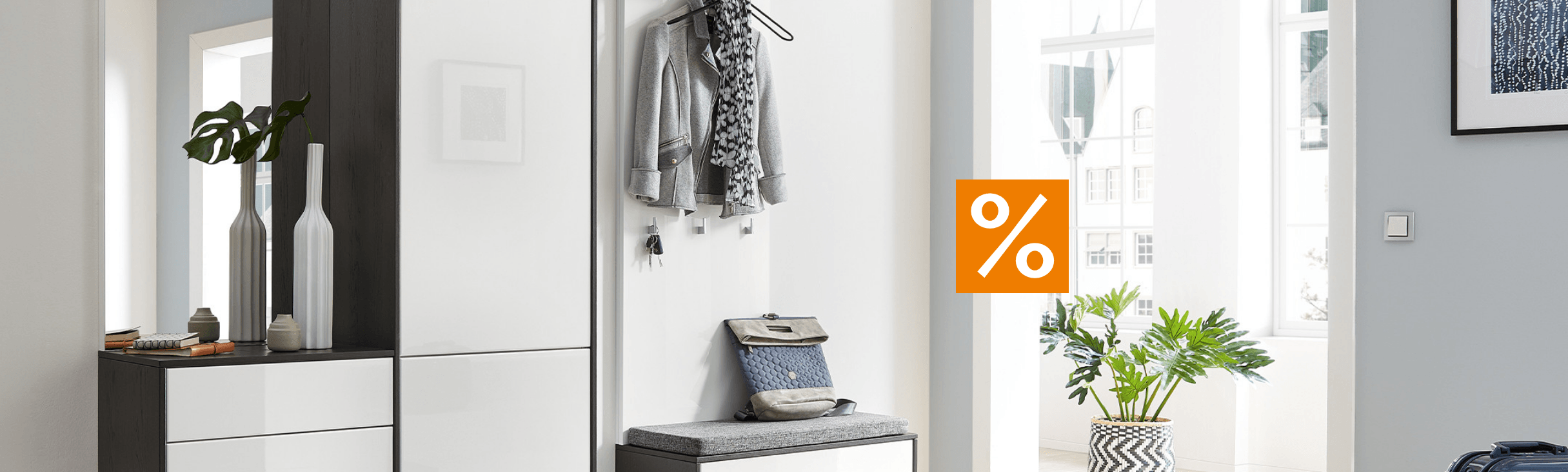 Moderne und helle Diele mit einer Garderobe, einem Schuhschrank und dekorativen Akzenten. Ein Prozentsymbol hebt Rabattaktionen hervor.