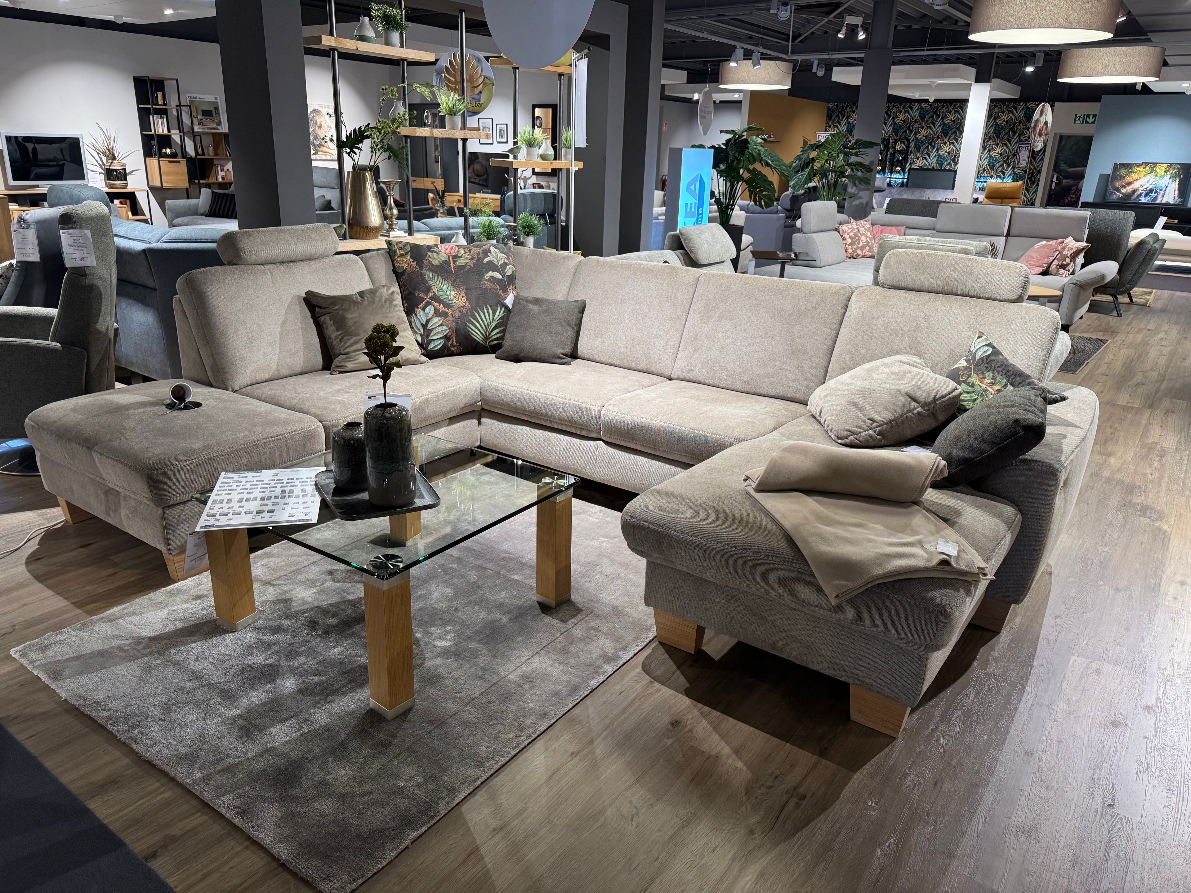 Mandelfarbene Couchgarnitur in U-Form mit farblich abgesetzten Kissen