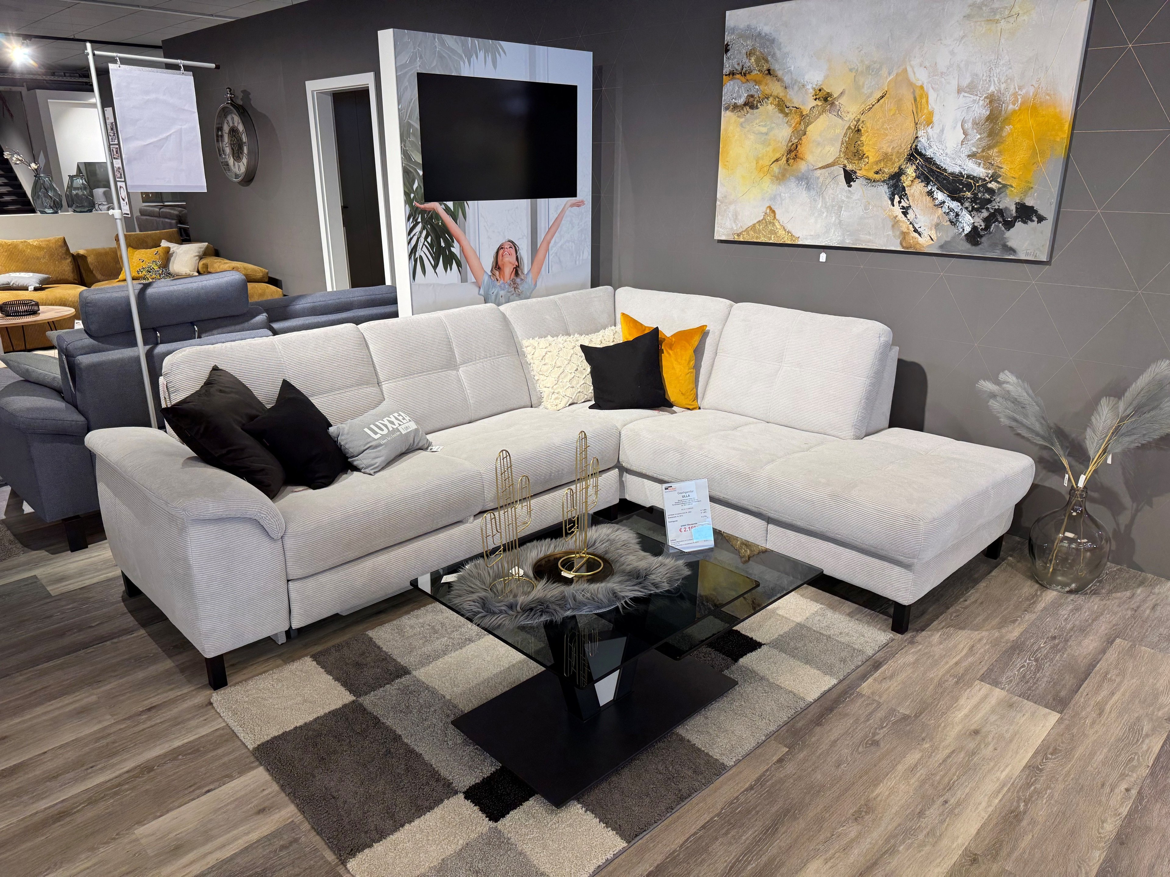 Couchgarnitur in silberfarbenen Cordstoff mit schwarzen Füßen und schwarz-goldenen Kissen