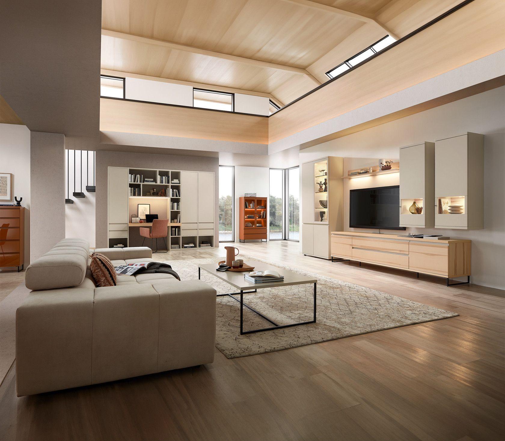 Offener Wohnbereich mit TV-Wand, einem eleganten Sofa und stilvoller Beleuchtung. Offener Wohnbereich mit TV-Wand, einem eleganten Sofa und stilvoller Beleuchtung.
