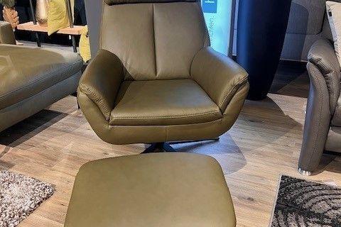 Olivgrüner Relaxsessel aus Echtleder mit passendem Hocker und schwarzem Drehgestell, arrangiert in einem modernen Wohnraum.